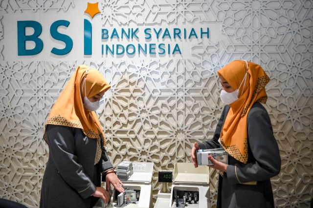 Tellers count United States dollar banknotes on May 11, 2023, at the Bank Syariah Indonesia (BSI) branch on Jl. Thamrin in Central Jakarta.
