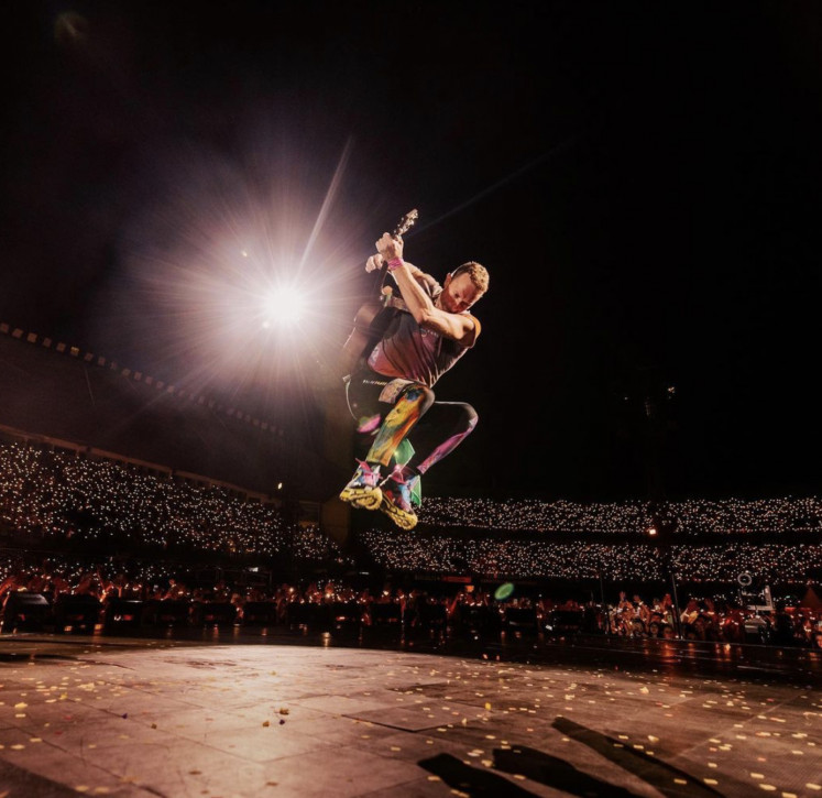 Stadium draw: Coldplay front man Chris Martin jumps while performing on March 21 in Curitiba, Brazil, during the British band's Music of the Spheres World Tour. (Instagram/Coldplay)