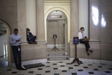 Reporters wait outside the office of US Speaker of the House Kevin McCarthy on May 23, 2023, in Washington, DC as negotiations on the debt ceiling remained unresolved.