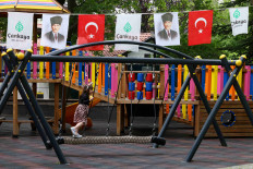 A child plays at a playground next to portraits of modern Turkey's founder Mustafa Kemal Ataturk ahead of the May 28 runoff vote, in Ankara, Turkey, May 26, 2023. 