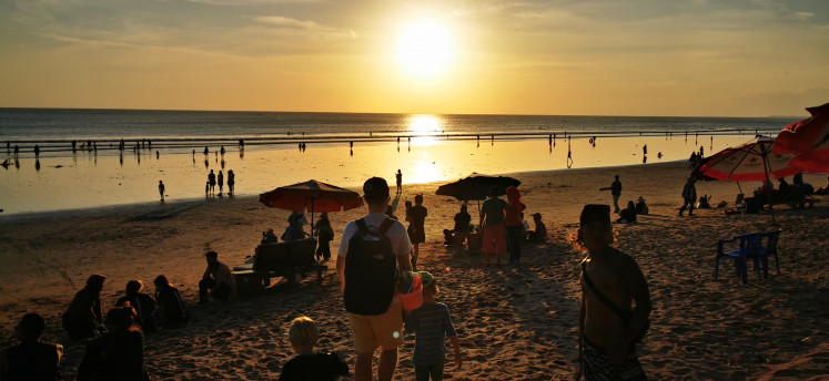 Tourists flock to Kuta beach in Bali at sunset on May 31, 2023.
