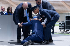 US President Joe Biden is helped up after falling during the graduation ceremony at the United States Air Force Academy, just north of Colorado Springs in El Paso County, Colorado, on June 1, 2023. 
