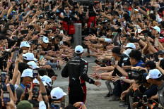 Tag Heuer Porsche’s German Formula E driver Pascal Wehrlein greets fans after winning the 10th series of the Formula E race at the Jakarta International e-Prix Circuit in Jakarta on June 3.