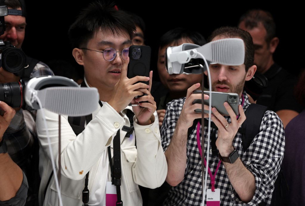  Members of the media inspect the new Apple Vision Pro headset during the Apple Worldwide Developers Conference on June 05, 2023 in Cupertino, California. Apple CEO Tim Cook kicked off the annual WWDC22 developer conference with the announcement of the new Apple Vision Pro mixed reality headset. 
