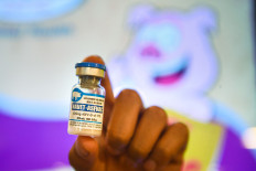 A man holds a vial of an African swine fever vaccine for pigs during a presentation of the vaccine on June 3, 2022, in Hanoi.