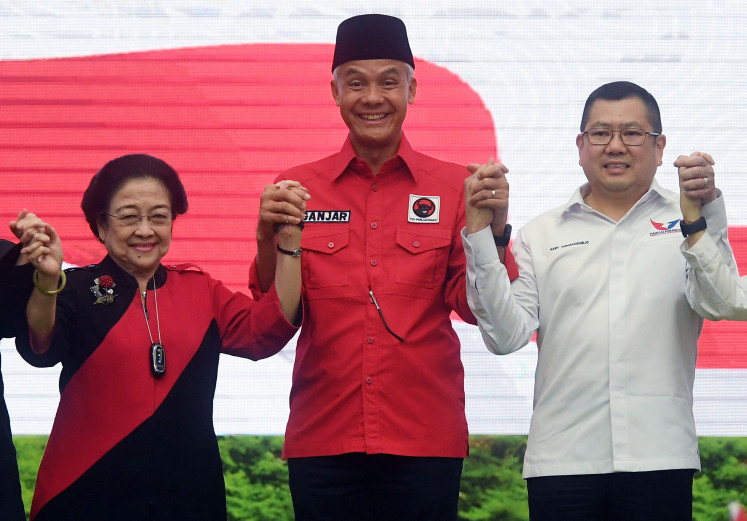 Indonesian Democratic Party of Struggle (PDI-P) chairwoman Megawati Soekarnoputri (left) and Perindo Party Hary Tanoesoedibjo (right) pose elbow-to-elbow with presidential nominee Ganjar Pranowo (center) after the signing of a political contract between the two sides in Jakarta, on June 9, 2023.