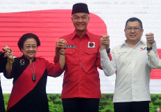 Indonesian Democratic Party of Struggle (PDI-P) chairwoman Megawati Soekarnoputri (left) and Perindo Party Hary Tanoesoedibjo (right) pose elbow-to-elbow with presidential nominee Ganjar Pranowo (center) after the signing of a political contract between the two sides in Jakarta, on June 9, 2023.