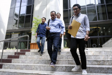 Indonesia Corruption Watch researcher Kurnia Ramadhana (right) leaves the Constitutional Court in Jakarta on June 12, 2023. The ICW is a member of the Civil Society for Clean Elections, which is seeking to overturn a 2023 regulation that allows ex-graft convicts to run for public office again less than five years after they first completed their prison term.