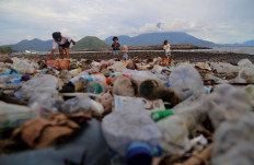 Children play near plastic waste on Sasa Beach in Ternate, North Maluku, on June 11, 2023.