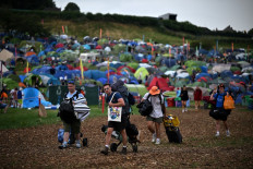 Festivalgoers arrive with their belongings on the first day of the Glastonbury festival in the village of Pilton, in Somerset, southwest England, on June 21, 2023.
