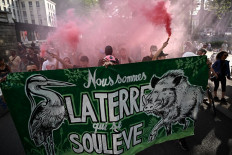 Protesters march behind a banner reading “we are the earth that rises up“ during a rally to support the environmental movement “Les Soulevements de la Terre“ (Uprisings of the Earth) in Nantes, western France, on June 21, 2023, to protest against the decision by the government to dissolve the movement.