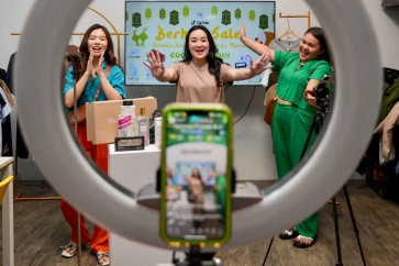 Christine Febriyanti (center), owner of a TikTok sales channel called Monomolly, and her employees offer merchandise through a TikTok livestream at a room in Jakarta on April 4, 2023.