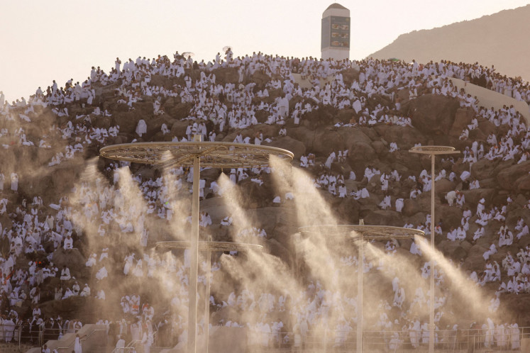 Muslim pilgrims gather on June 27, 2023 on the Mount of Mercy in the plain of Arafat, located outside the holy city of Mecca, Saudi Arabia, as a misting tower sprays water amid high temperatures during the annual haj.