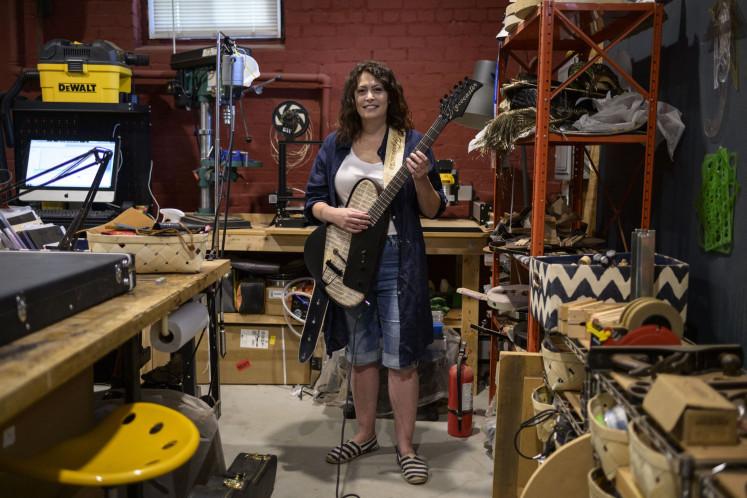 French luthier Rachel Rosenkrantz poses for a portrait with her “Mycocaster,“ a mycelium and paper guitar, in her studio on June 21, 2023, in Providence, Rhode Island, the United States.