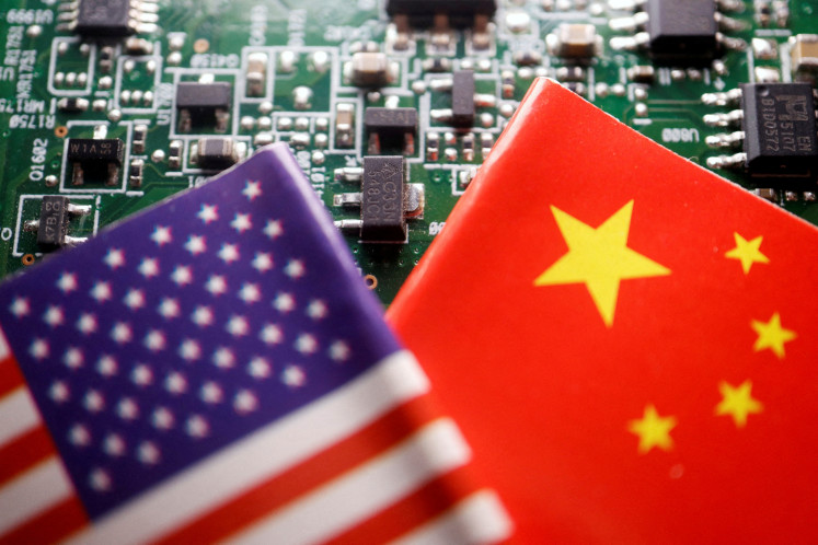 Flags of China and the US are displayed on a printed circuit board with semiconductor chips, in this illustration picture taken on Feb. 17, 2023.