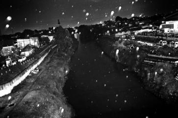The Ciliwung river at night time as rain pours down on Rawajati, Jakarta.