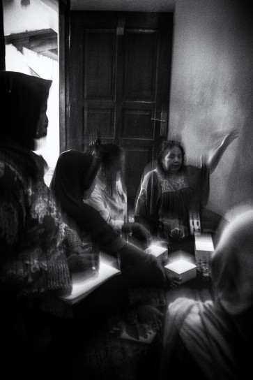 The head of Sekolah Perempuan Ciliwung Rawajati Musriyah (right) presents educational material on domestic violence on the banks of Ciliwung river in Rawajati, South Jakarta.