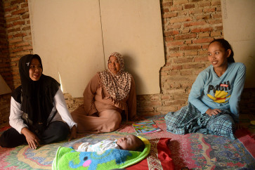 Ike (left) with Alviatin’s mother (right) checks on Alviatin’s health.