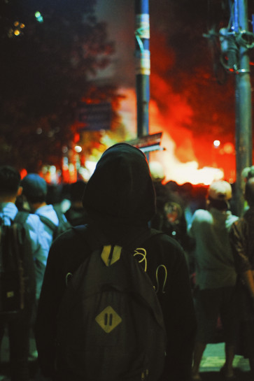 A man looking at a fire near the demonstration site.