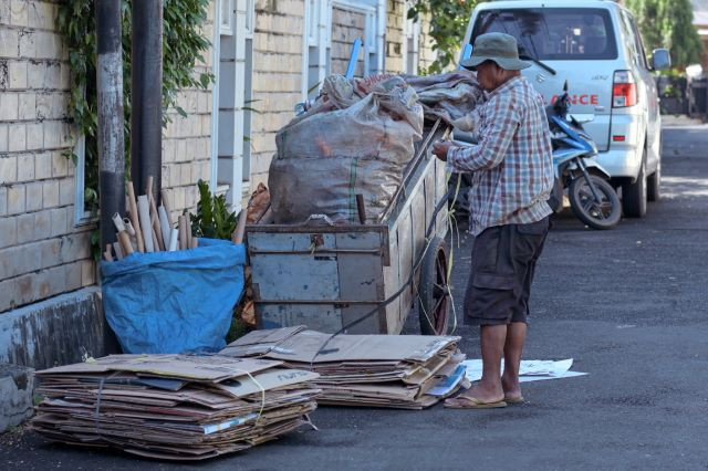 Street economy: A scavenger ties up used cardboard boxes he salvaged to sell for recycling in Jakarta on Feb. 22, 2022. Extreme poverty in Jakarta stood at 0.89 percent of the population as of March 2022, according to Statistics Indonesia, with the city government aiming to bring it to zero next year.
