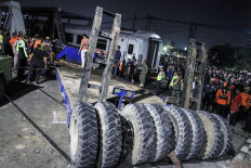 Twisted metal: Rescuers and volunteers work to remove the wreckage of an unloaded flatbed truck that was hit by a train in Semarang, Central Java, on Tuesday, July 18, 2023.