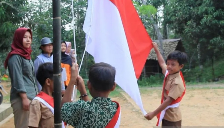 Children of the Orang Rimba indigenous community take part in a flag-raising ceremony on Aug. 17, 2022, to commemorate the 77th anniversary of Indonesian independence at Bukit Duabelas National Park in Sarolangun regency, Jambi.