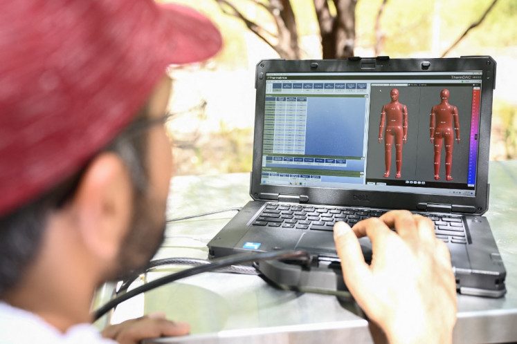 Ankit Joshi configures a software program to regulate and monitor the temperatures of ANDI, an Advanced Newton Dynamic Instrument, as researchers prepare a heat and wind experiment to learn more about the effect of heat exposure on the human body at Arizona State University (ASU) during a record heat wave in Phoenix, Arizona on July 20.