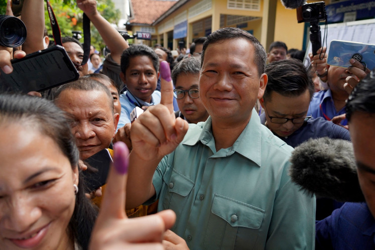 Hun Manet, then commander of the Royal Cambodian Army and eldest son of Prime Minister Hun Sen, shows his finger after he casts his vote at a polling station in Phnom Penh on July 23, 2023.