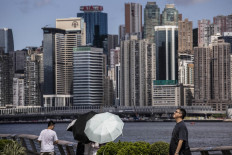 People walk along a promenade along Victoria Harbour in Hong Kong, China, on July 11, 2023.