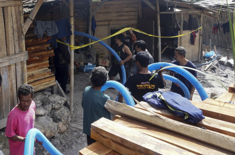 Rescue workers insert a hose to extract water from an illegal gold mining pit on July 26, 2023, at Pancurendang village in Banyumas, Central Java, in an effort to rescue eight miners trapped underground. 