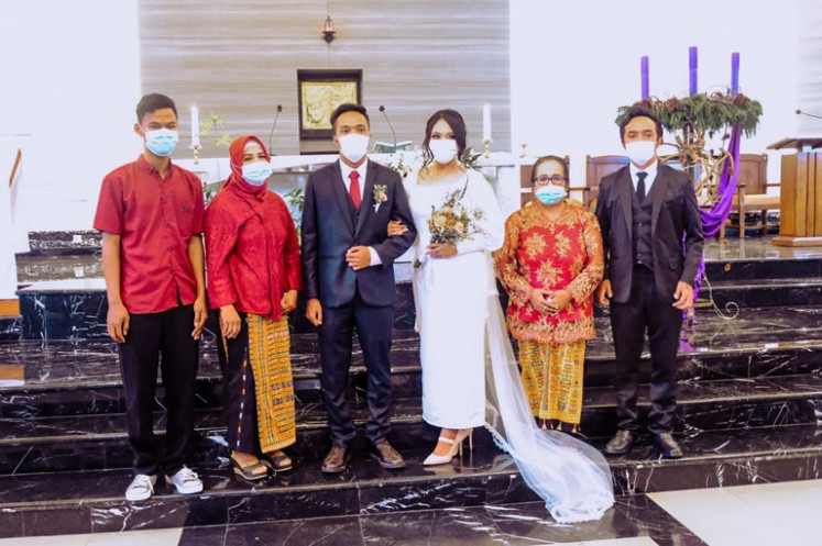 Eugenius Audax Aditya (third left) and Tegar Yudha Restuti (fourth left) pose for a wedding photo with their family members on Dec. 4, 2020, after their Catholic marriage ceremony at the Santo Leo Agung Church in Jakarta.