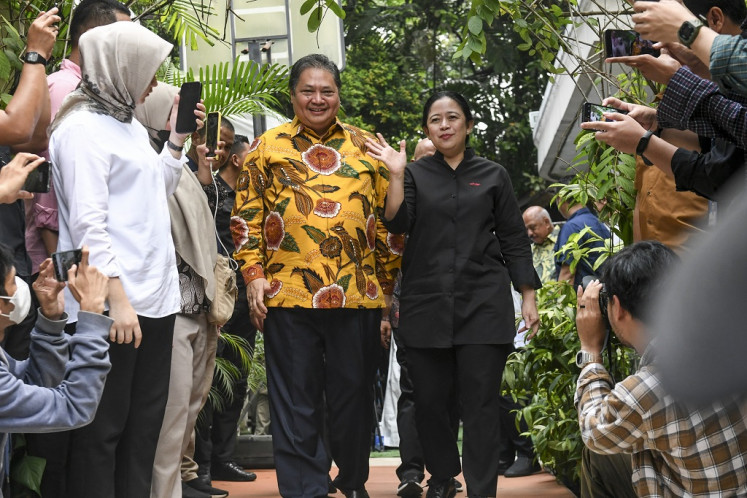 Golkar Party chairman Airlangga Hartarto (left) walks with senior Indonesian Democratic Party of Struggle (PDI-P) official Puan Maharani (right) during Puan’s visit to Airlangga’s private residence in Jakarta on July 27, 2023.