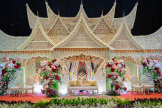 The Menara Danareksa Wedding Expo presents a traditional house of the Minangkabau culture as stage backdrop for a wedding reception