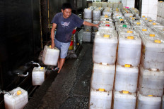 A trader fills a conductor of cooking oil at Tanah Abang Market, Central Jakarta, Wednesday (11/01). The government is targeting Indonesia to be free from the habit of consuming bulk cooking oil in 2015, and switch to bottled oil. 