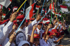 Elementary school pupils wave Red-and-White flags on Jl. Raya Bogor in Cibinong, Bogor regency, West Java, on Aug. 1, 2023. Hundreds of students gathered at the vicinity in a celebration of the nation's 78th Independece Day anniversary, which falls on Aug. 17.