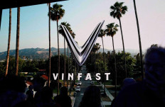 FILE PHOTO: People walk next to a VinFast logo on a screen during the press day at the Los Angeles Auto Show in Los Angeles, California, U.S. November 17, 2022. REUTERS/Mike Blake/File Photo/File Photo