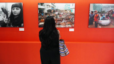 A visitor examines a photograph on Aug. 5, 2023 at “Portraits of a Nation”, an exhibition in Palmerah, Jakarta, of the work of The Jakarta Post's photojournalists in commemoration of the paper’s 40th anniversary.