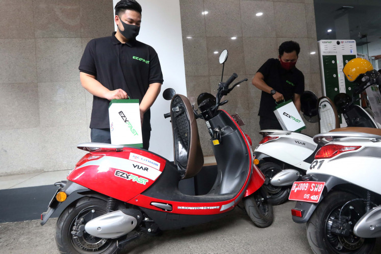 Officials exchange electric motorcycle batteries at Public Electric Vehicle Battery Exchange Station (SPBKLU) in the Electrification Director General building, Jakarta, on Aug. 31, 2020. T
