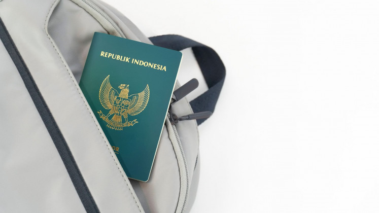 An Indonesian passport peeks out of a backpack in this stock illustration.