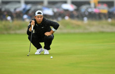 South Korea's Tom Kim lines up a putt on the 18th green on July 23, 2023, on day four of the 151st British Open Golf Championship at Royal Liverpool Golf Course in Hoylake, northwest England.