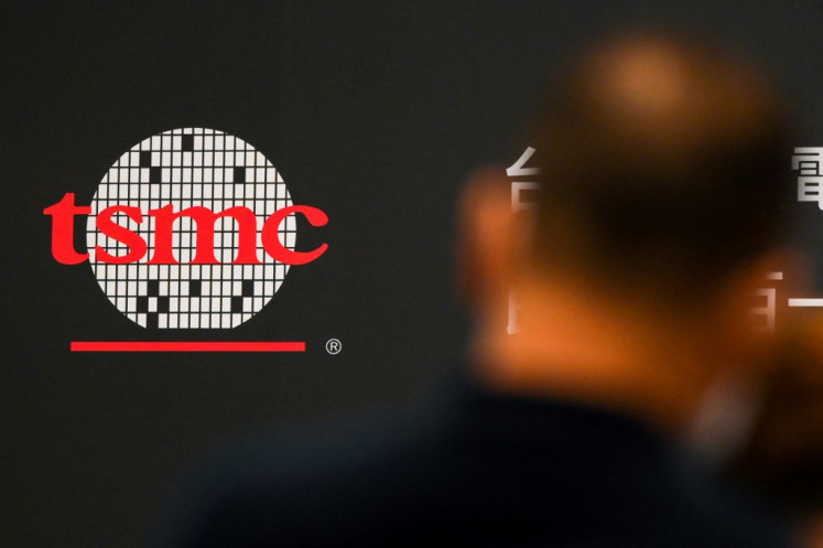 A man walks past a logo of Taiwan Semiconductor Manufacturing Company (TSMC) on June 6, 2023, during a shareholder meeting in Hsinchu, Taiwan. Taiwanese chip giant TSMC said on August 8, 2023, that its board had approved a US$3.8 billion investment in a factory in Germany, as well as a capital injection of $4.5 billion to its Arizona plant.