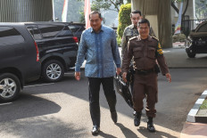 Former trade minister Muhammad Lutfi (left) walks toward a building at the Attorney General's Office (AGO) complex in Jakarta on July 9, 2023, to undergo questioning by investigators as a witness in a graft case pertaining to domestic cooking oil shortages in 2022.