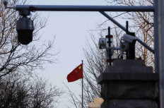 A Chinese flag is seen near surveillance cameras outside the Beijing No. 2 Intermediate People's Court in Beijing, China.