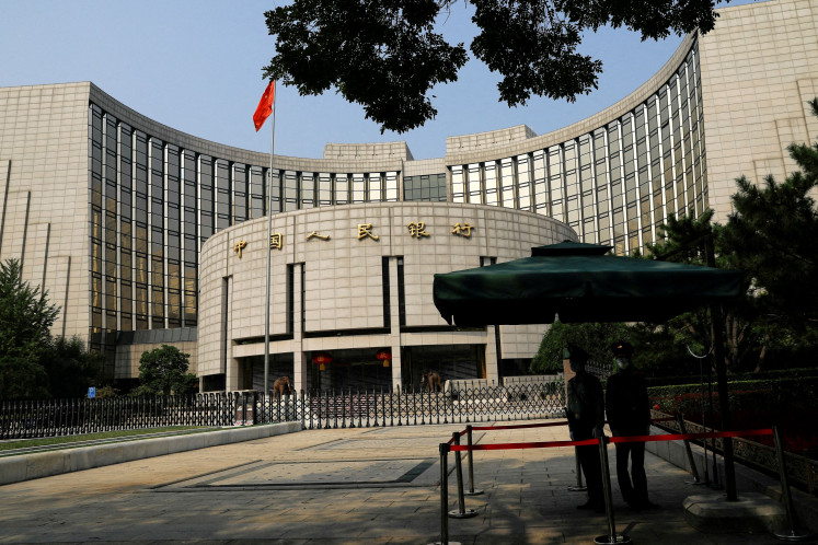Police officers stand guard in front of the headquarters of the People's Bank of China (PBOC), China's central bank, in Beijing on Sept. 30, 2022.