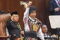 President Joko “Jokowi“ Widodo raises a fist while delivering his State of the Nation Address on Aug. 16, 2023 at the House of Representatives in Jakarta.