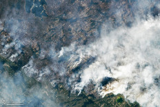 This handout satellite image courtesy of NASA Earth Observatory taken on Aug. 16, 2023 shows wildfires burning northeast of Yellowknife, Northwest Territories, Canada. Thousands ordered to flee wildfires advancing on one of the largest cities in Canada's far north started leaving on emergency evacuation flights August 17, 2023, as convoys snaked south to safety on the only open highway.