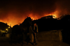 Oscar, 21, rescues his horse Atena in the village of La Victoria, as wildfires rage out of control on the island of Tenerife, Canary Islands, Spain on Aug. 19, 2023.