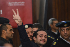 Leading Egyptian opposition campaigner Ahmed Douma flashes the V-sign for victory in court during his trial on Feb. 4, 2015 in Cairo, along with 230 activists from the 2011 revolt against Hosni Mubarak, all sentenced to life in prison. Thirty-nine other defendants, all minors, were sentenced to 10 years in prison with all 269 defendants found guilty of taking part in clashes with security forces near Cairo's Tahrir Square in December 2011, according to judicial sources.