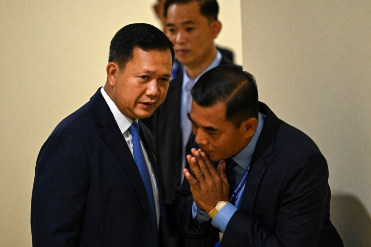 Cambodia's Prime Minister-designate Hun Manet (left) speaks with a body guard as he attends a parliamentary meeting at the National Assembly building in Phnom Penh on August 22, 2023. Cambodia’s parliament on August 22 elected long-time ruler Hun Sen’s eldest son as the country’s new prime minister, sealing a dynastic handover of power after last month’s one-sided election.
