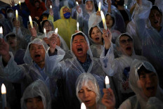 Members of South Korea's main opposition Democratic Party chant slogans during a candlelight vigil against Japan's plan to release treated wastewater from the Fukushima nuclear power plant into the ocean, at the National Assembly in Seoul, South Korea, August 23, 2023.   